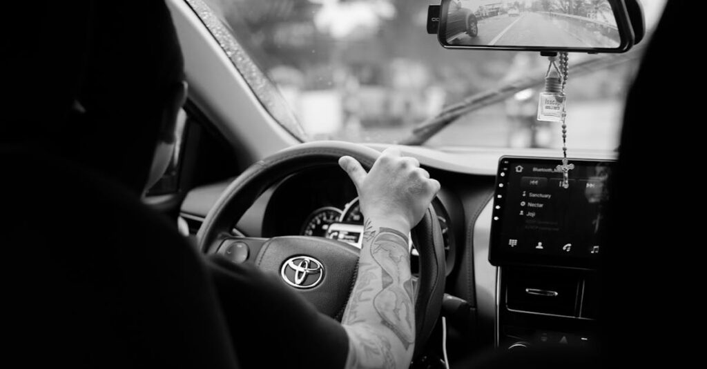 Monochrome image featuring a driver in a Toyota car interior, showcasing a focused driving experience.